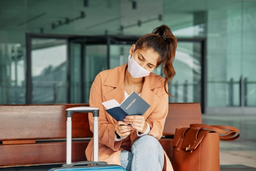 Passenger waiting at the airport, looking at her passport