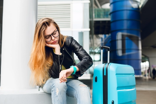 Passenger waiting at airport with her luggage