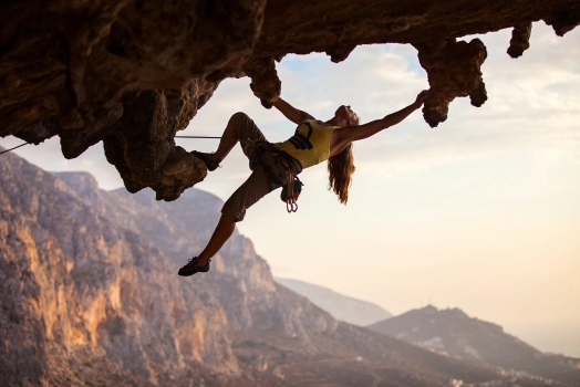 Rock climber climbing at sunset